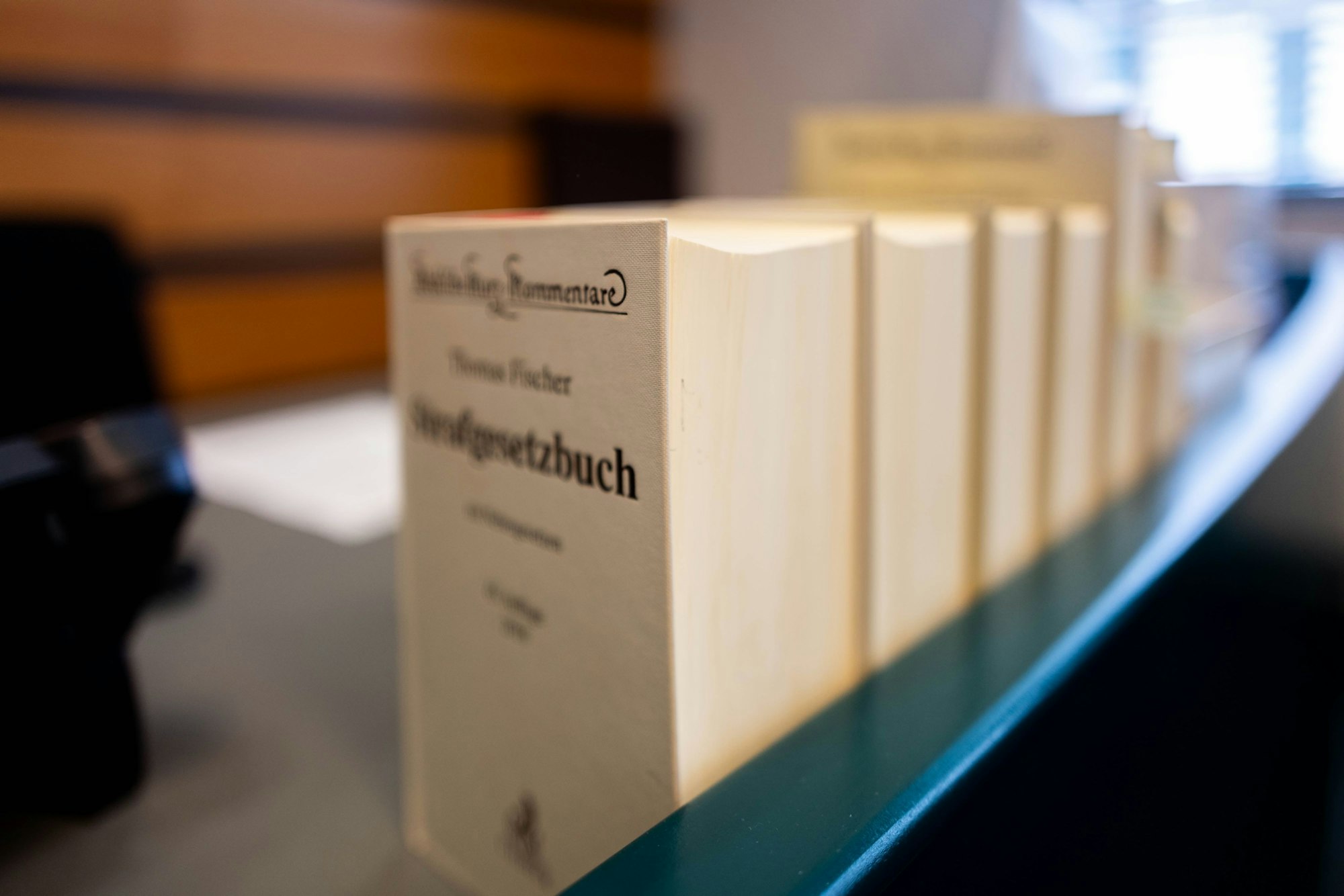 Mehrere Bücher der Strafprozessordnung stehen auf einem Richterpult.