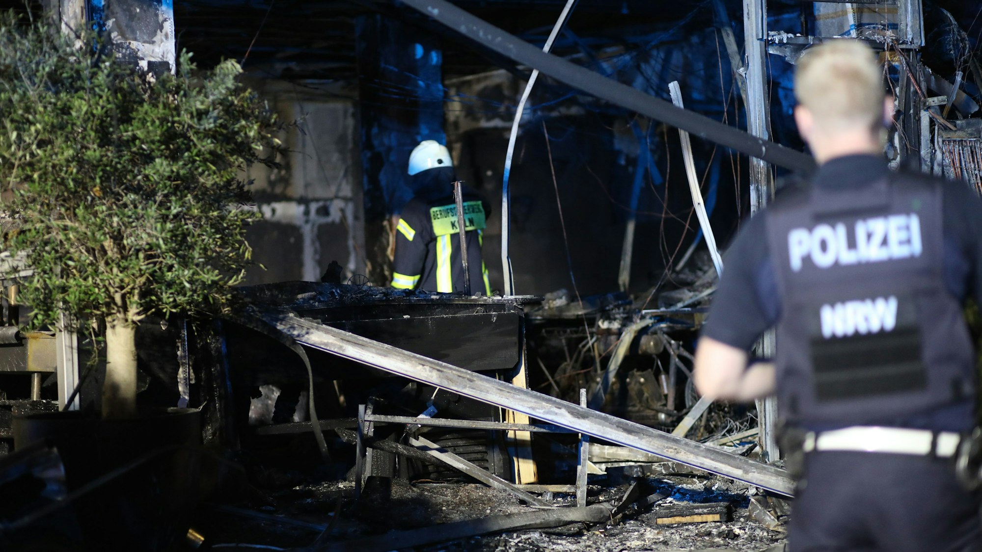 25.09.2024, Köln: Bei einer Explosion in einem Ladenlokal in Pesch sind zwei Personen leicht Verletz worden. Derzeit ermittelt die Polizei. Bewohner haben nach der Explosion zwei Personen vom Tatort weg laufen sehen. Videoaufzeichnungen werden nun ausgewertet. Der Wohnkomplex musste während der Löscharbeiten geräumt werden. Foto: Arton Krasniqi
