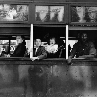 Menschen in einem Bus blicken auf die Straße.