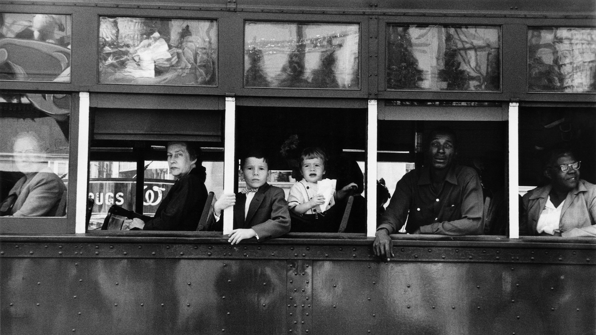 Menschen in einem Bus blicken auf die Straße.
