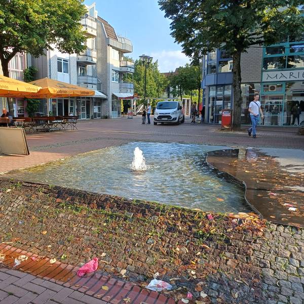 Ein Brunnen sprudelt auf einem Platz.
