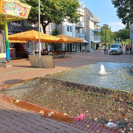 Ein Brunnen sprudelt auf einem Platz.