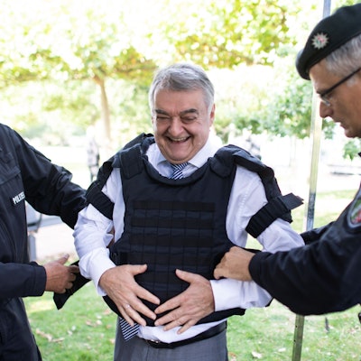 Polizisten legten Herbert Reul (CDU, M) bei der Vorstellung der neuen Köperschutzausstattung eine Schutzweste an.