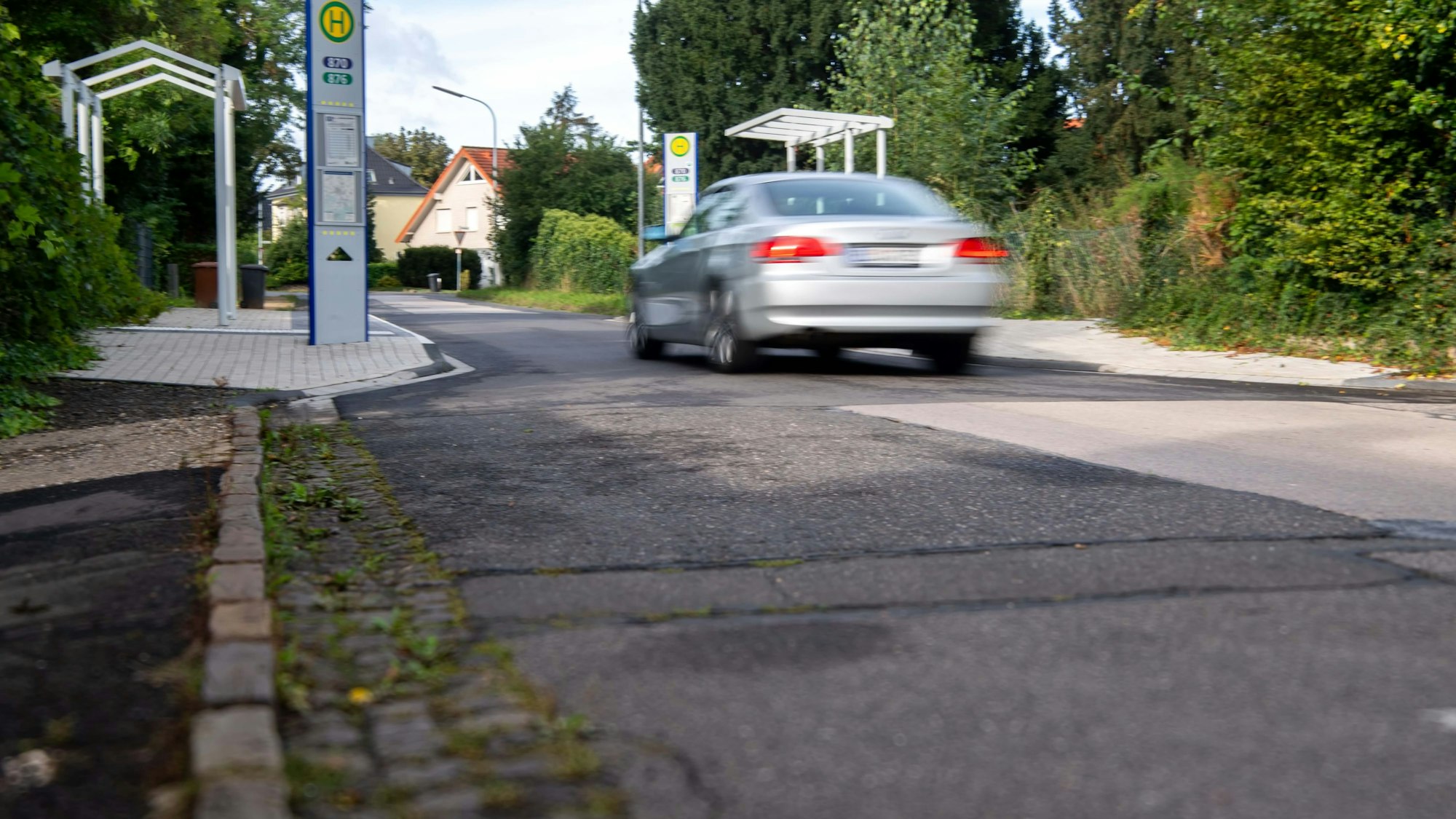 Das Bild zeigt die Carl-Koenen-Straße im Bereich der Stadtbushaltestelle. Ein Auto fährt gerade auf der Straße.