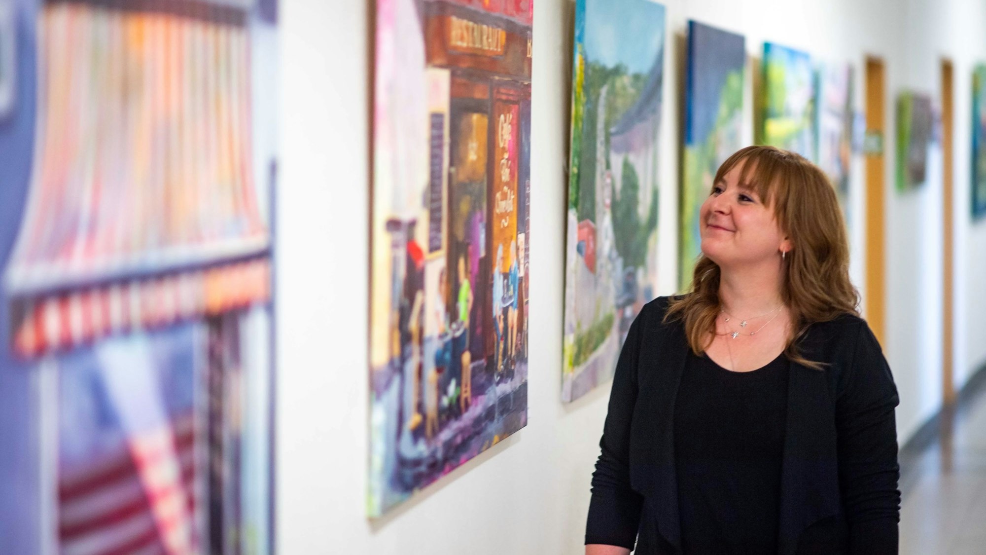 Das Bild zeigt Sabine Dünnwald, die im Flur des Rathauses steht und sich ein Bild anschaut.