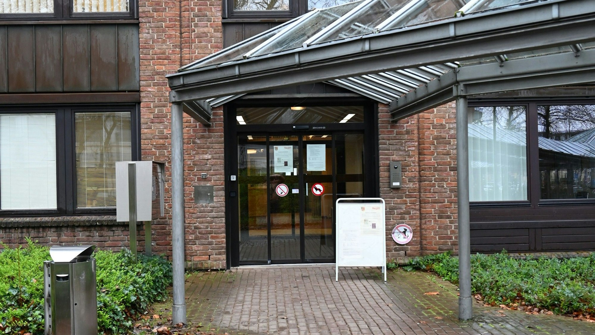 Zu sehen ist der überdachte Eingang eines Gebäudes aus Backstein.
