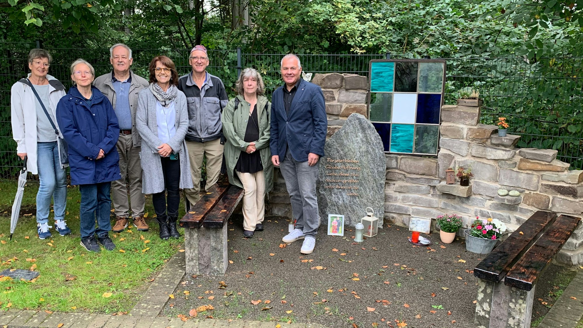 Menschen stehen auf einem Friedhof.