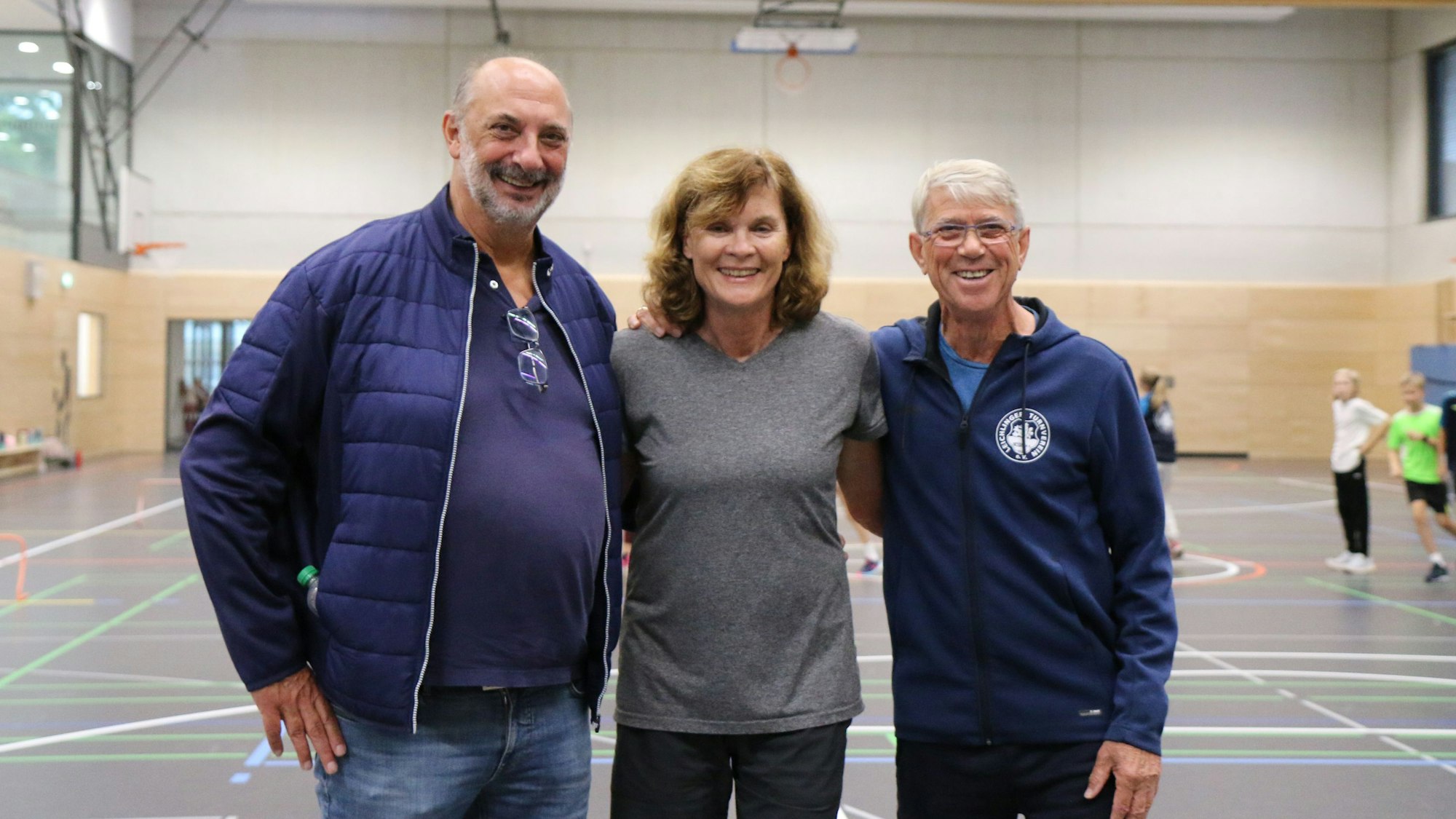 Nebeneinander stehen Manfred Schmitz, Ulrike Nasse-Meyfarth und Paul-Heinz Wellmann in der Sporthalle in der Balker Aue in Leichlingen.