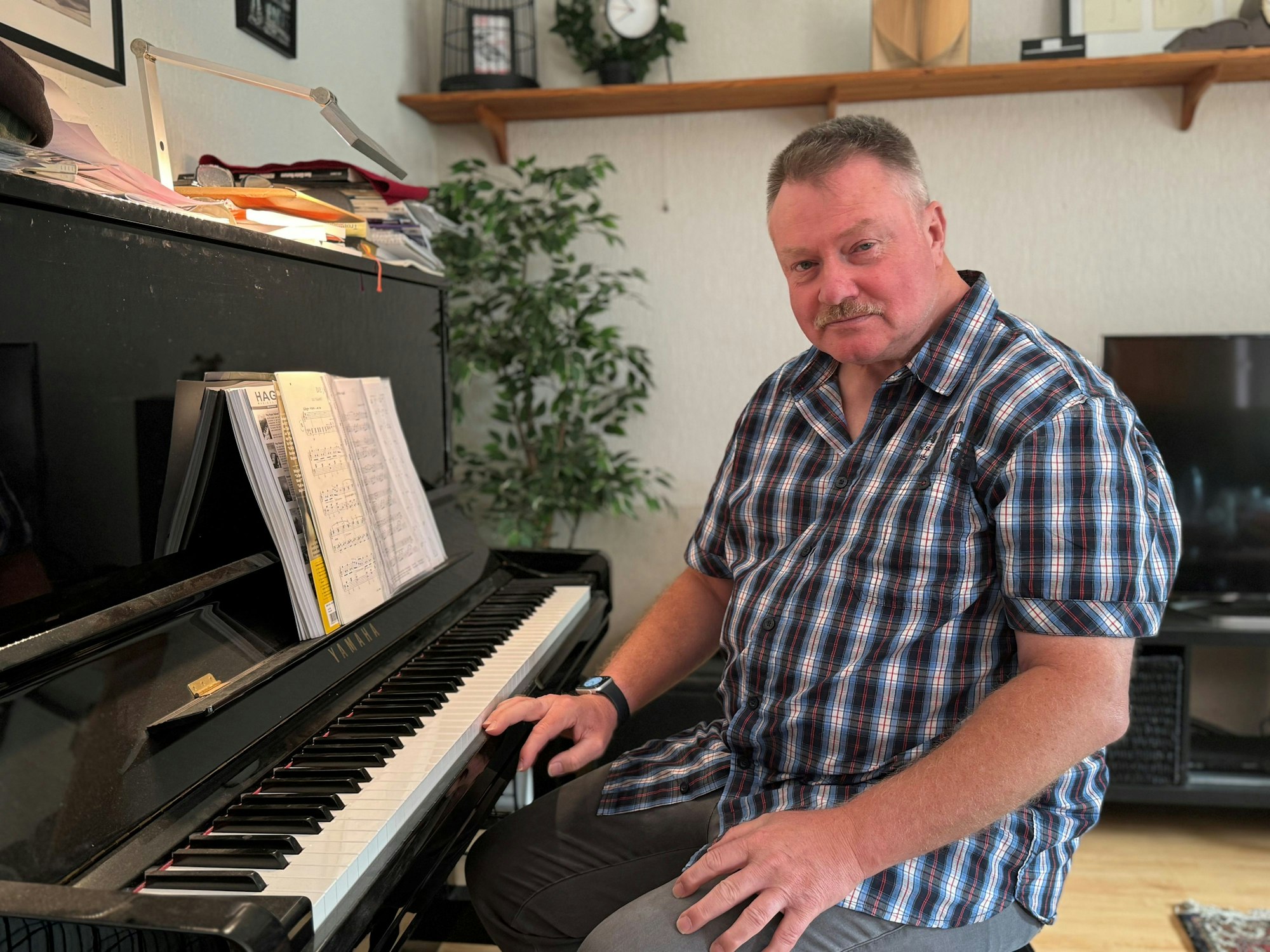 Werner Weisters sitzt am Klavier und schaut freundlich in die Kamera.