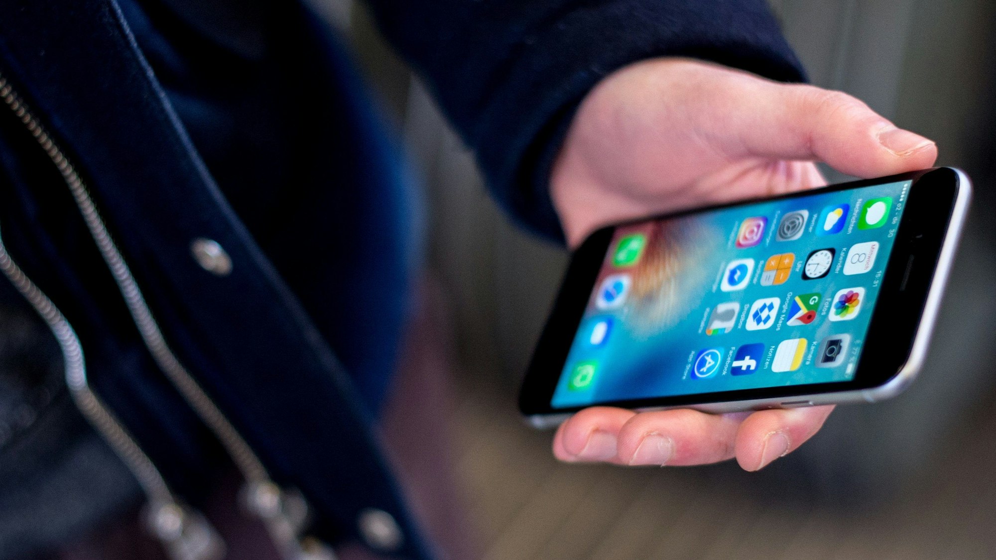 Das Symbolbild zeigt eine Hand, die ein Smartphone hält.