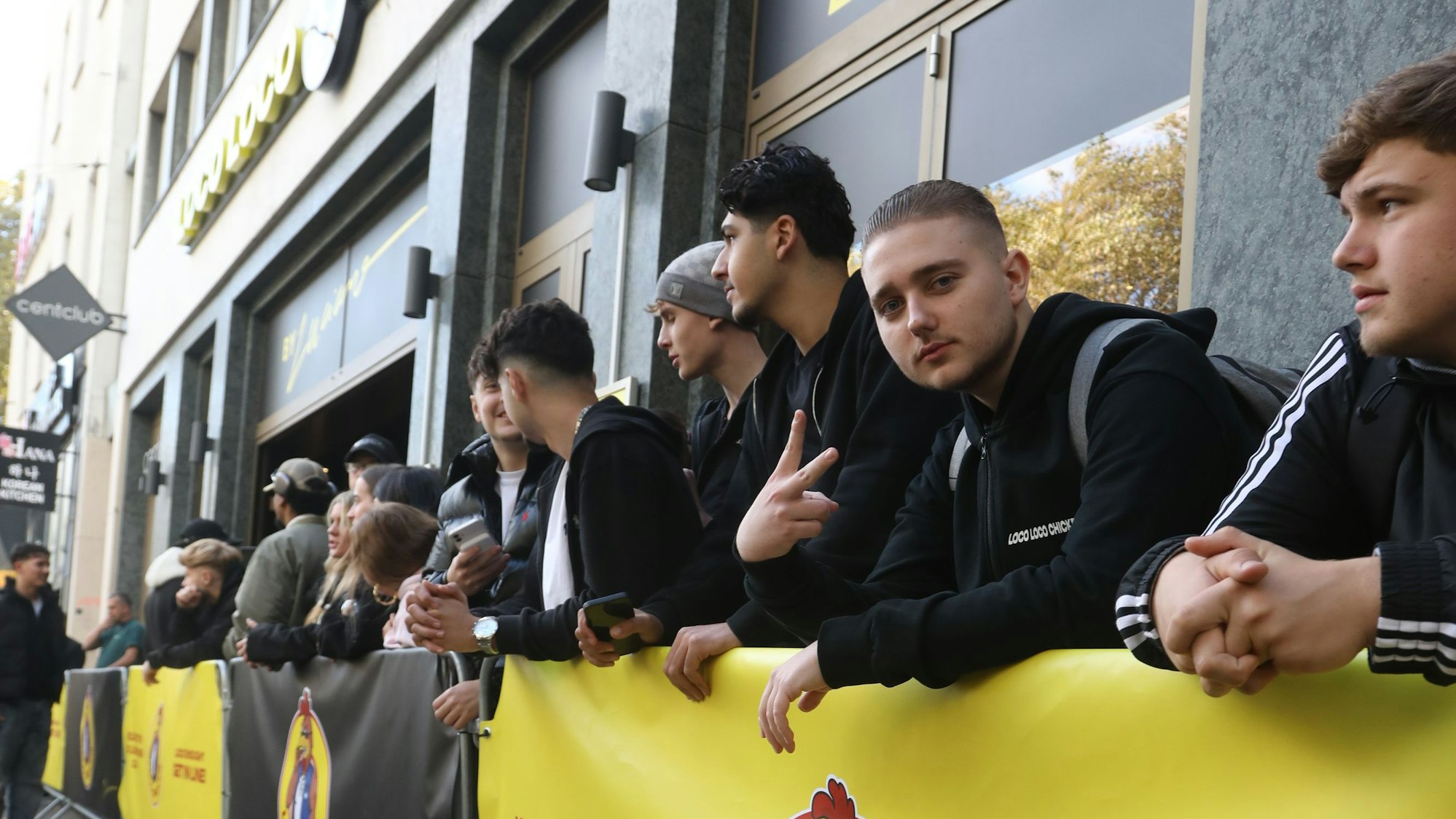 Zu sehen ist eine Menschenansammlung vor dem „Loco Chicken“ in Köln.