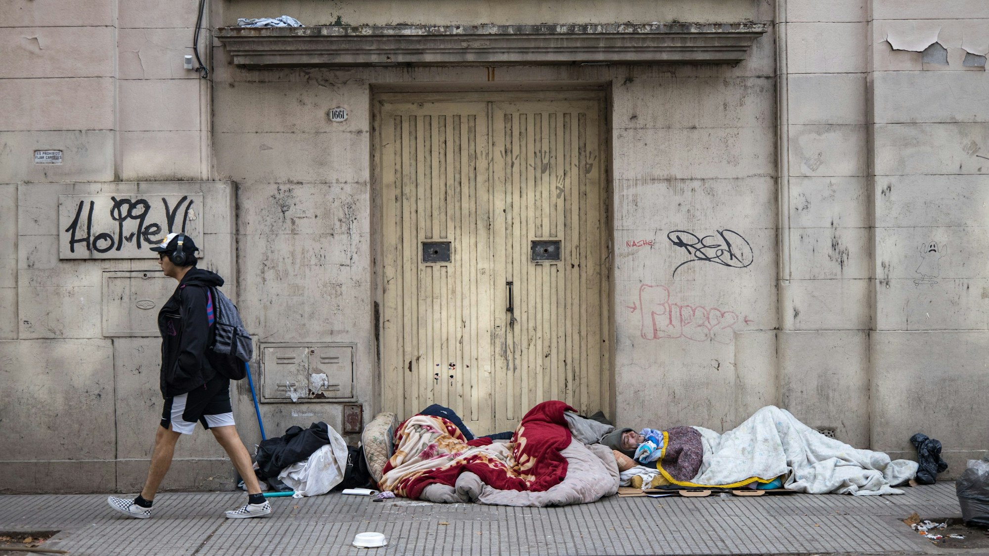 04.06.2024, Argentinien, Buenos Aires: Obdachlose schlafen vor dem Eingang eines Gebäudes.