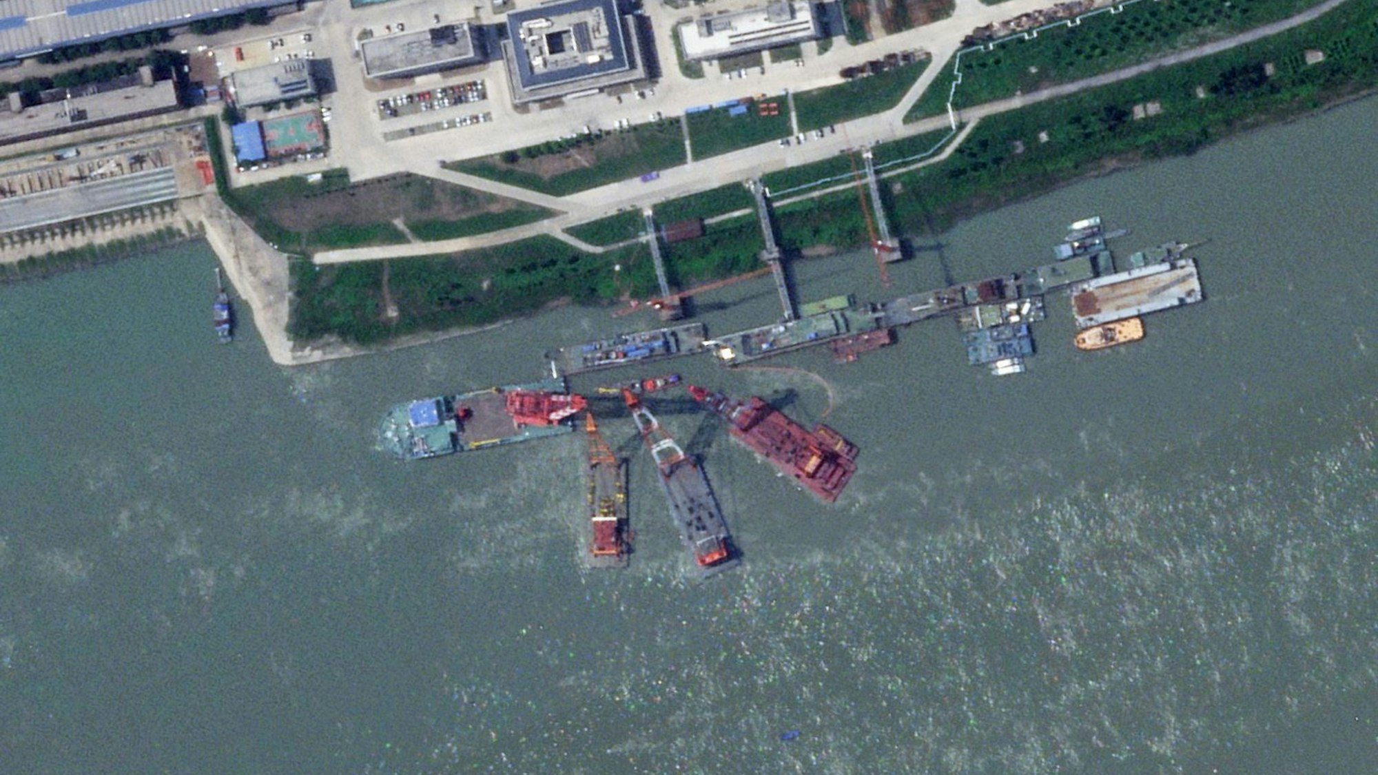 Dieses Satellitenbild von Planet Labs PBC zeigt Bergungsschiffe am Liegeplatz eines scheinbar gesunkenen, chinesischen U-Bootes in einer Werft in der Nähe von Wuhan.