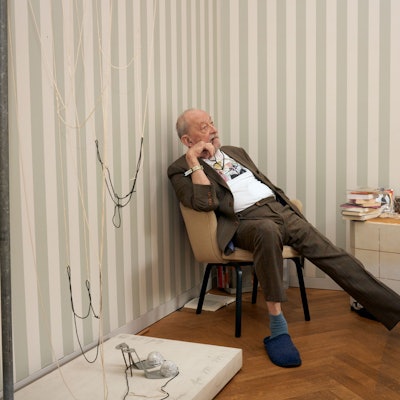 Kasper König sitzt entspannt auf einem Sessel.