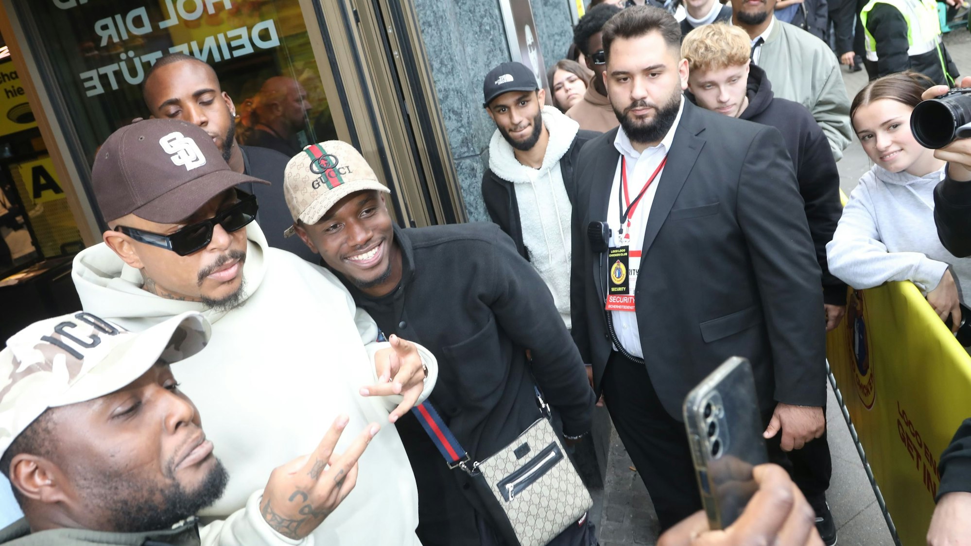 Zu sehen ist der Rapper Luciano, der Bilder mit seinen Fans vor dem „Loco Chicken“ in Köln macht.