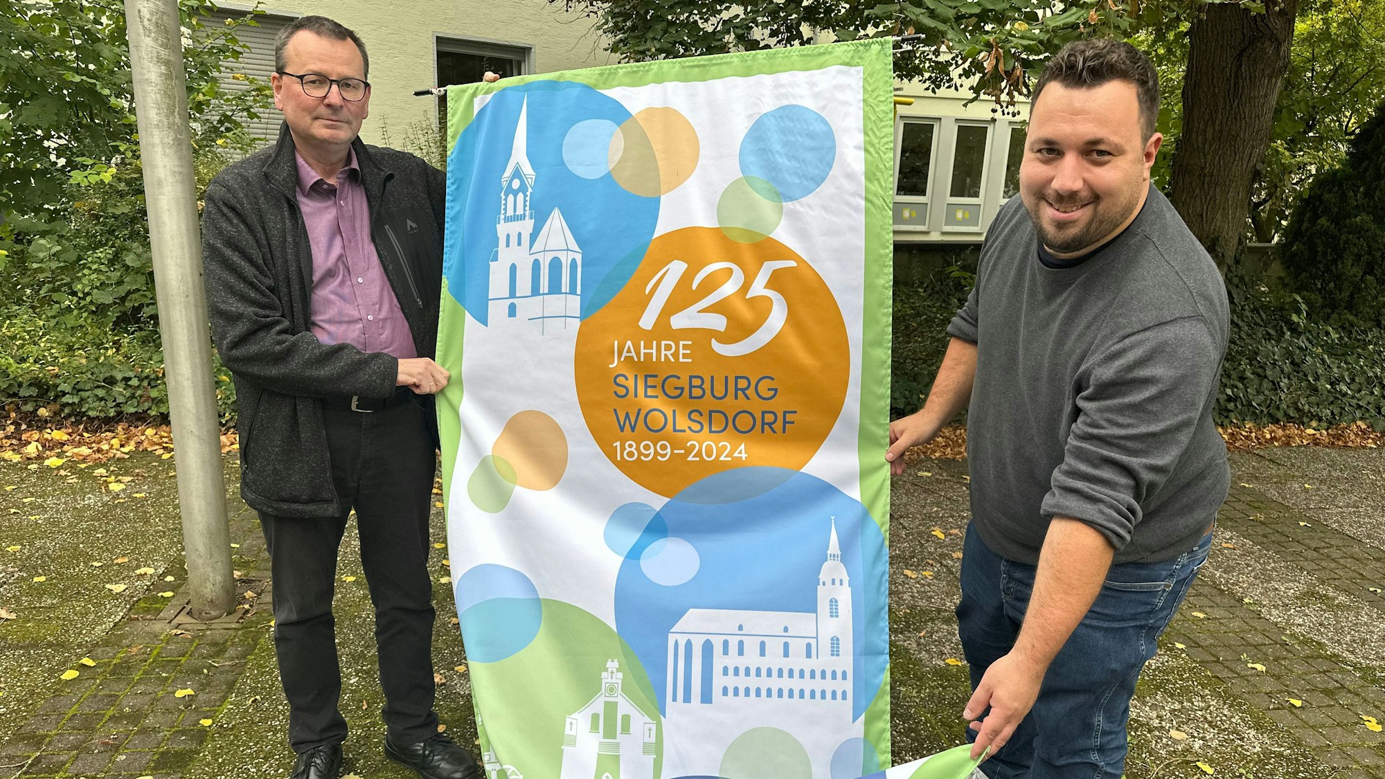 Zwei Männer mit einem Werbebanner