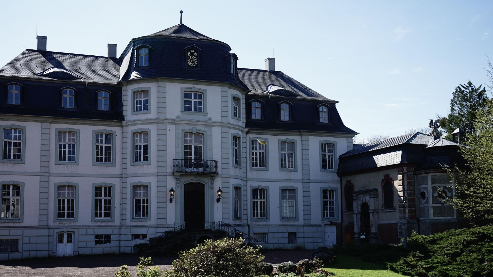Zu sehen ist das Herrenhaus eines weißen Schlosses.