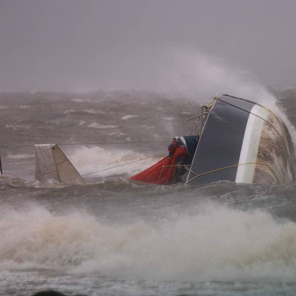 Ein Boot liegt im Wasser und wird von Fluten überspült.