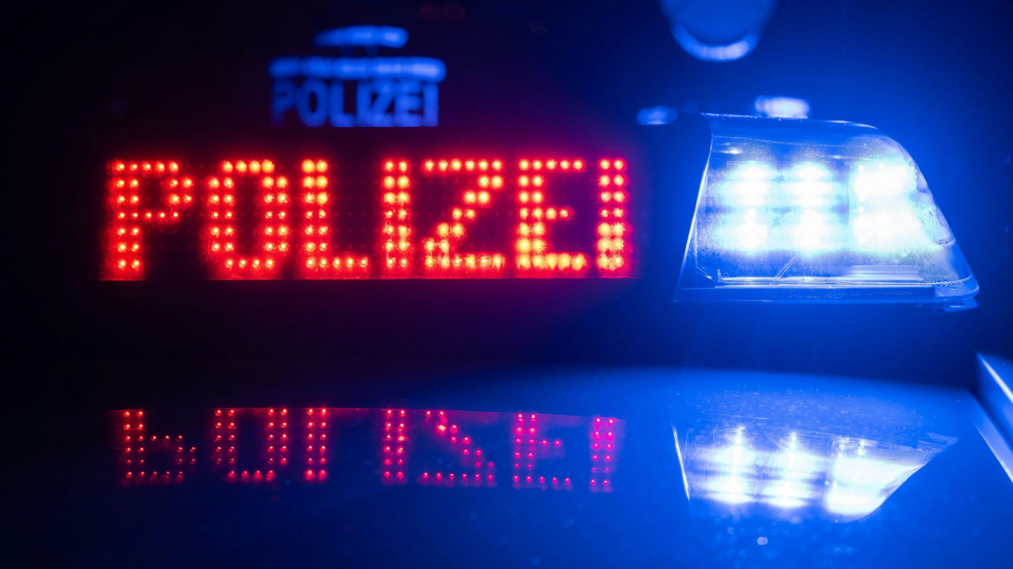 Das Bild zeigt den Schriftzug Polizei und ein Blaulicht auf einem Polizeifahrzeug.