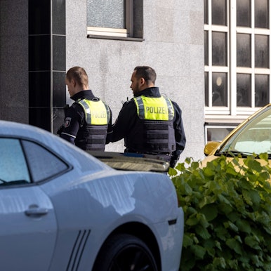 Essen: Zwei Polizeibeamte stehen vor dem Eingang des Gebäudes.