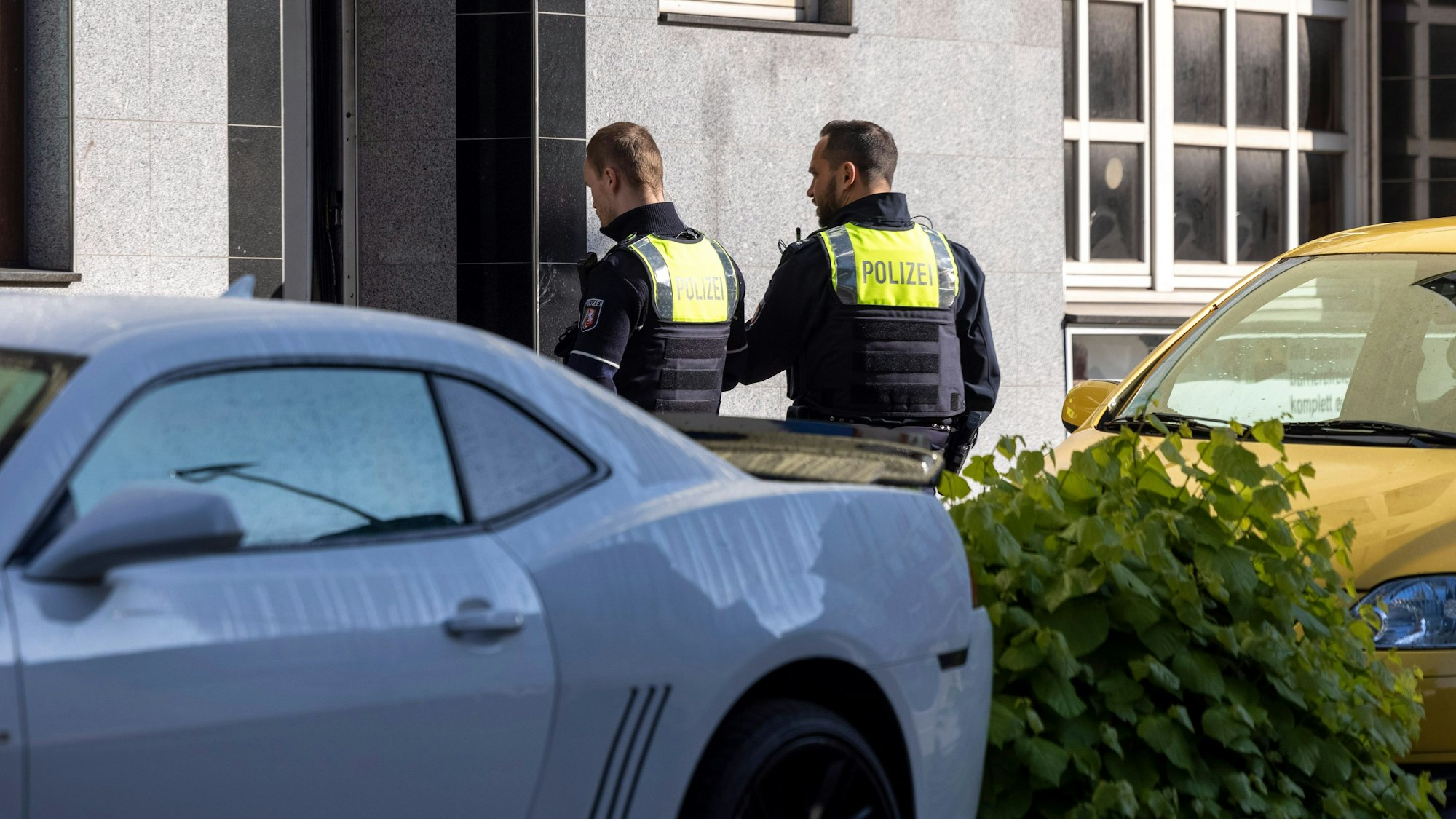 Essen: Zwei Polizeibeamte stehen vor dem Eingang des Gebäudes.
