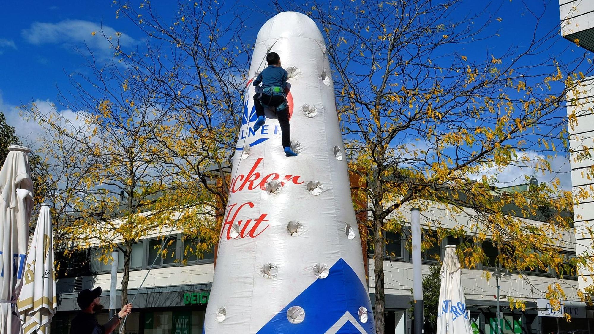 Das Bild zeigt einen Jungen, der gesichert einen Zuckerhut hochklettert. Der ist aber mit Luft gefüllt und nicht aus Zucker.