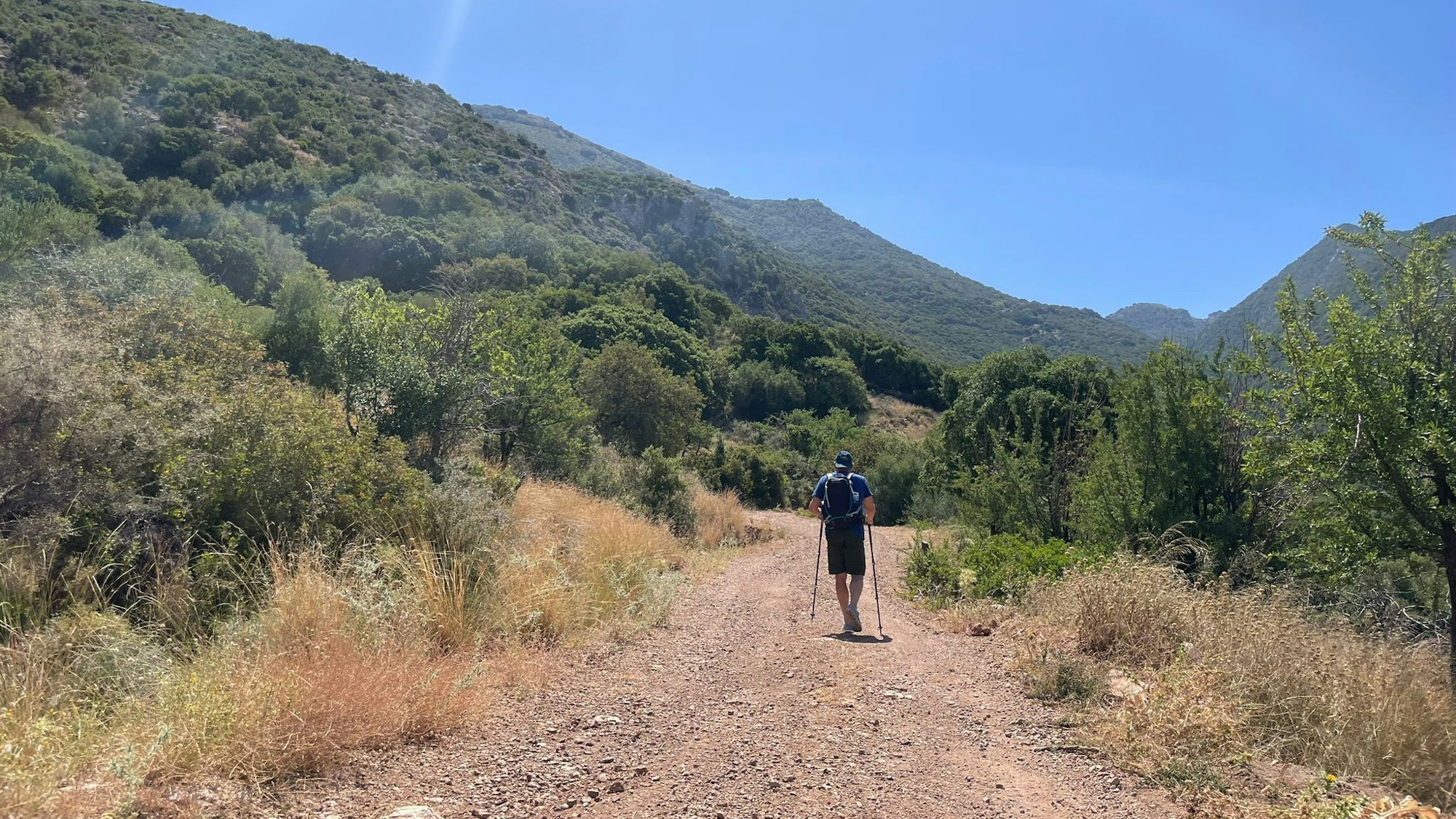 Ein Tourist geht bei wolkenlosem Himmel auf einer griechischen Insel Wandern (Symbolfoto).