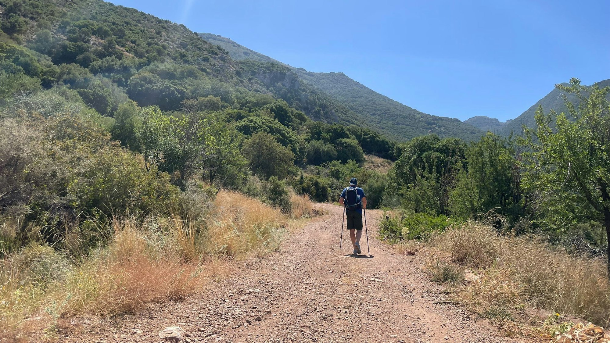Ein Tourist geht bei wolkenlosem Himmel auf der griechischen Halbinsel Peloponnes wandern.