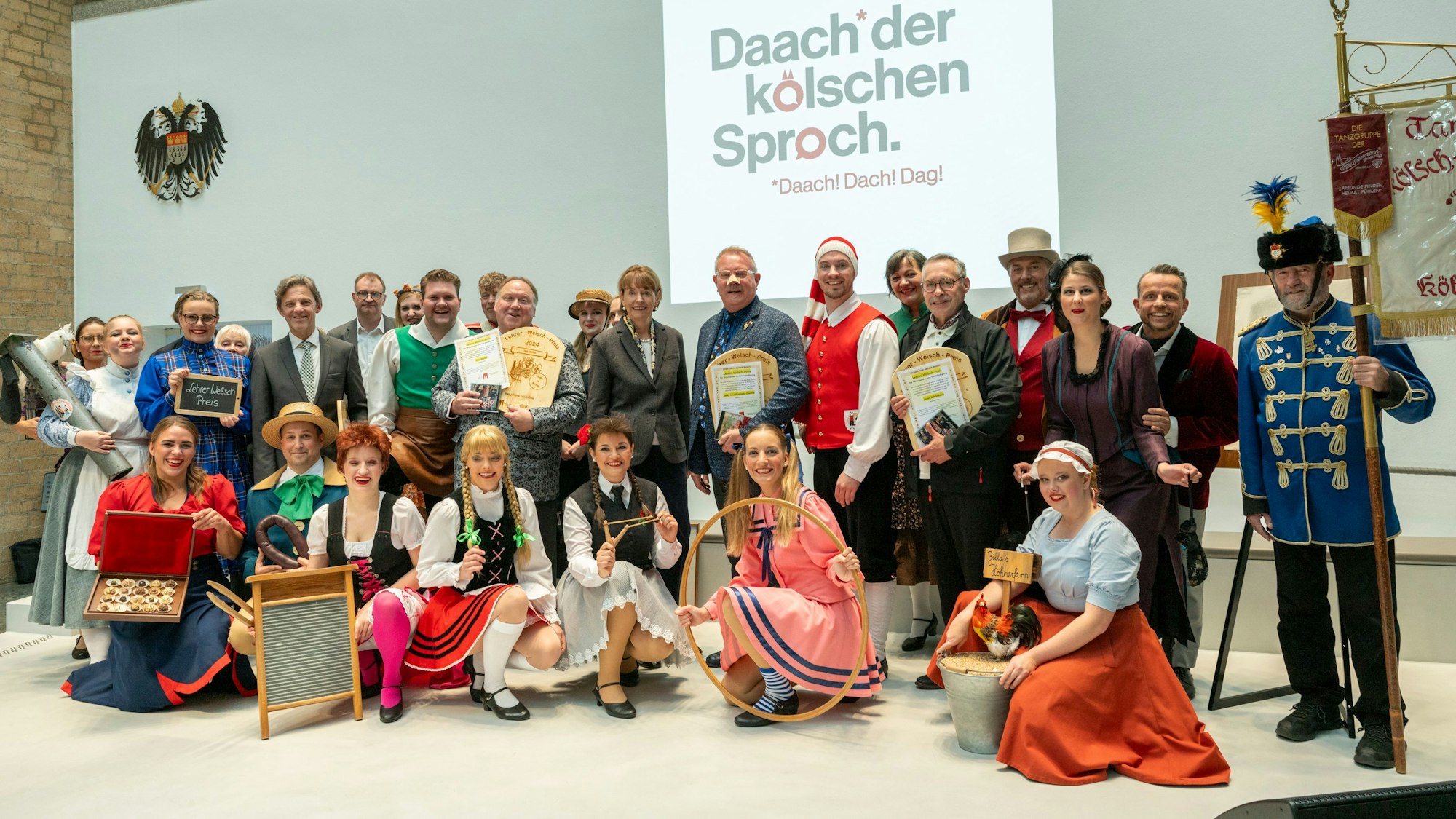 Die Preisträger des Lehrer-Welsch-Preises mit der Kölner Oberbürgermeisterin Henriette Reker und Mitgliedern der Tanzgruppe Kölsch Hänneschen im historischen Rathaus.