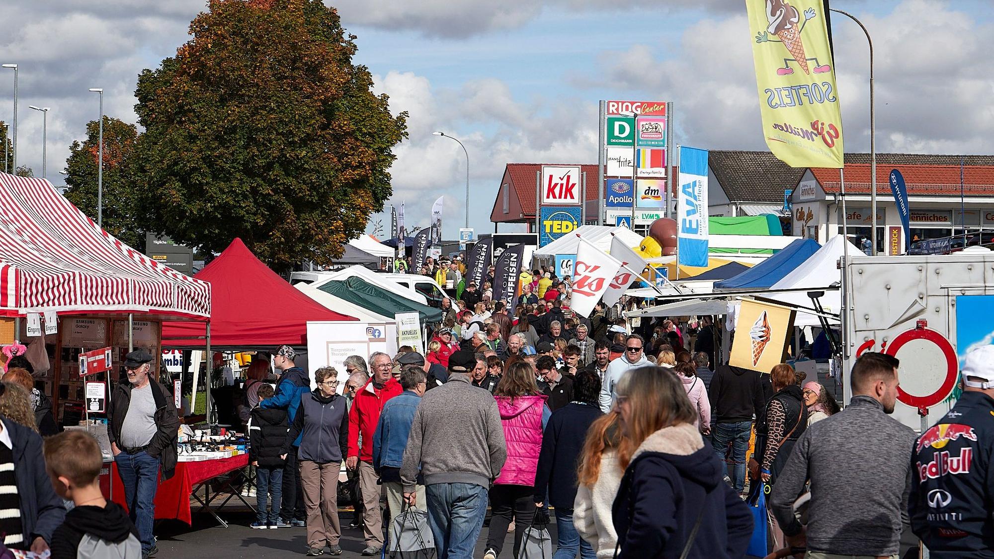 Die Straße zwischen den Ständen und Pavillons ist voller Menschen,.