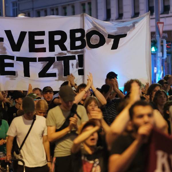 Teilnehmer einer linken Demonstration gehen mit Transparent mit der Aufschrift «AfD- Verbot jetzt!» eine Straße entlang.