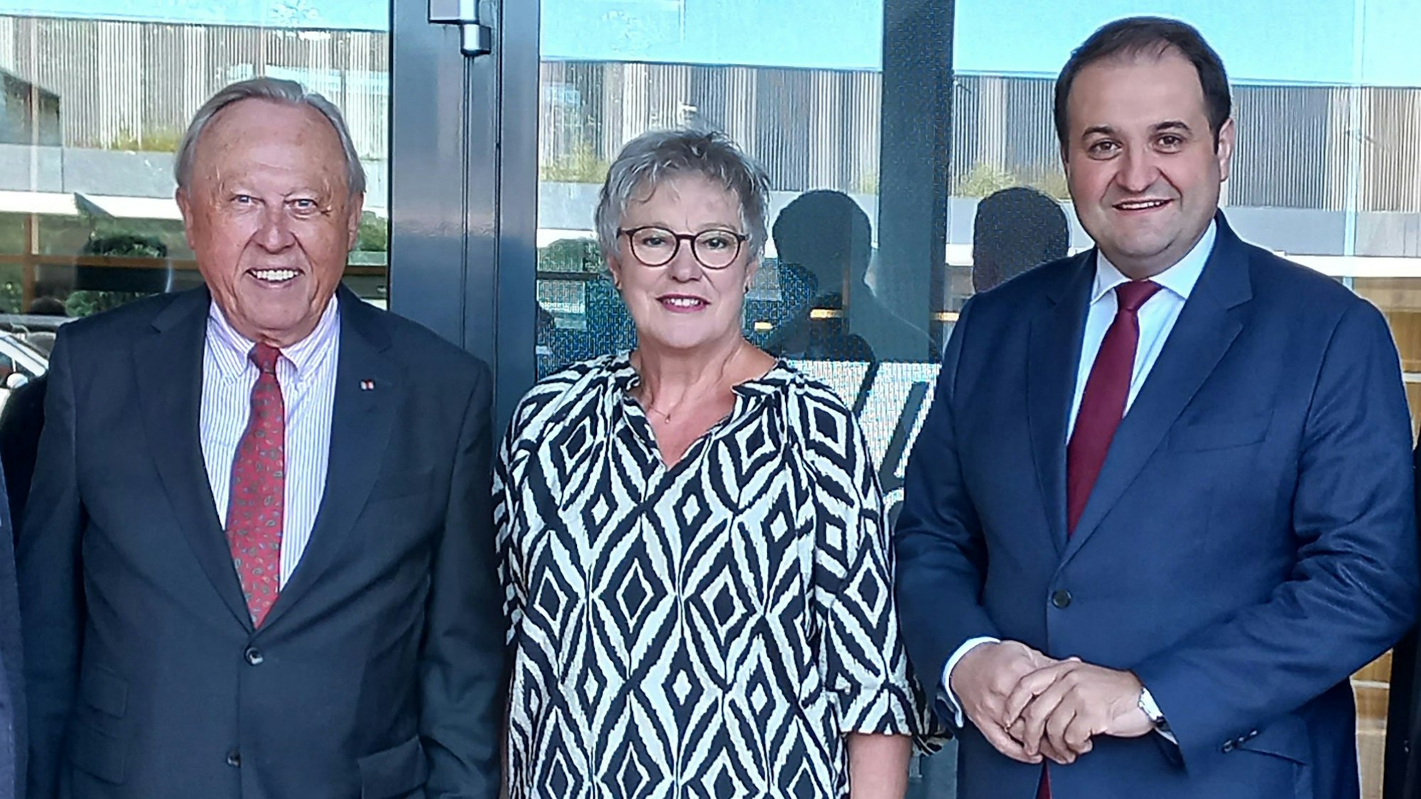 Zwei Männer, mit der Preisträgerin eines Bürgerpreises in ihrer Mitte, stehen beisammen.