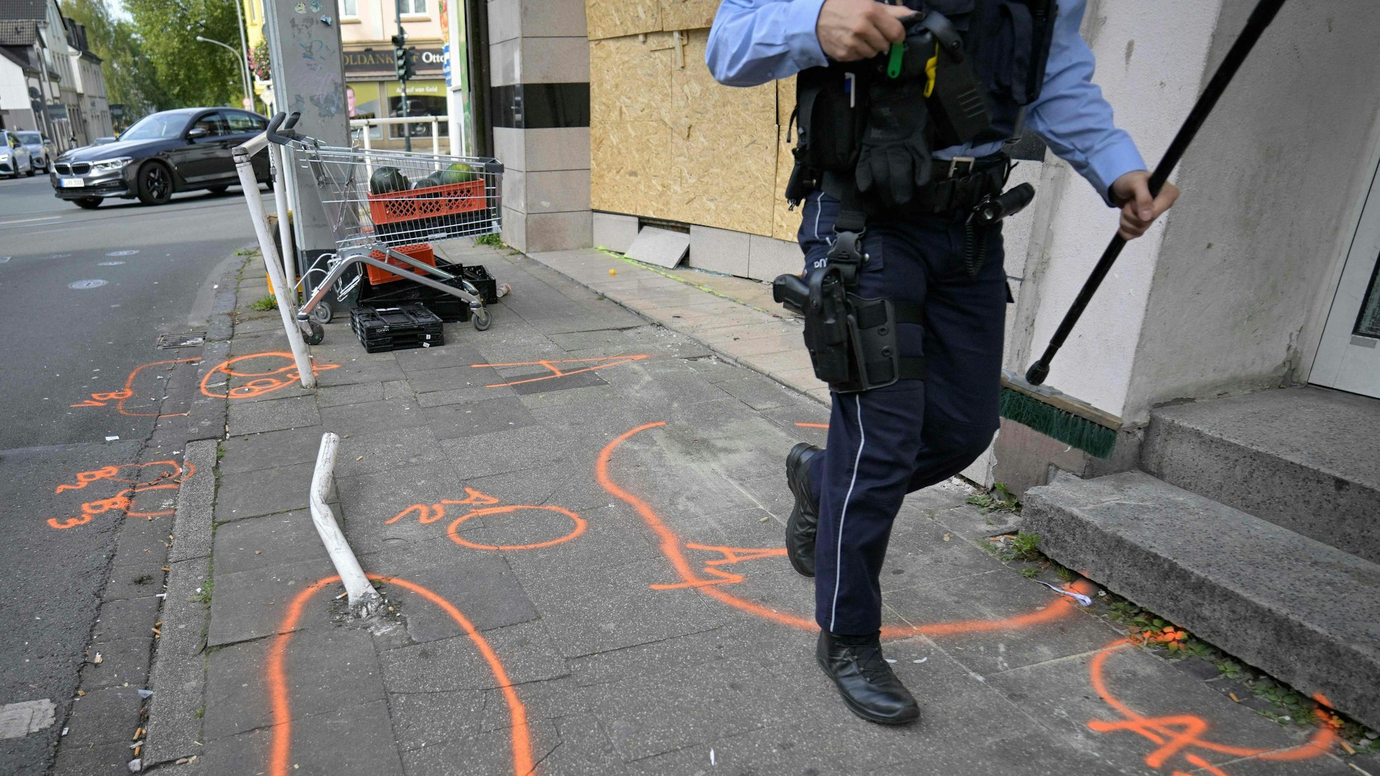 Ein Polizeibeamter patrouilliert am 29. September 2024 vor einem Lebensmittelgeschäft in Essen, wo ein Mann am Vortag einen Lieferwagen gerammt hat.