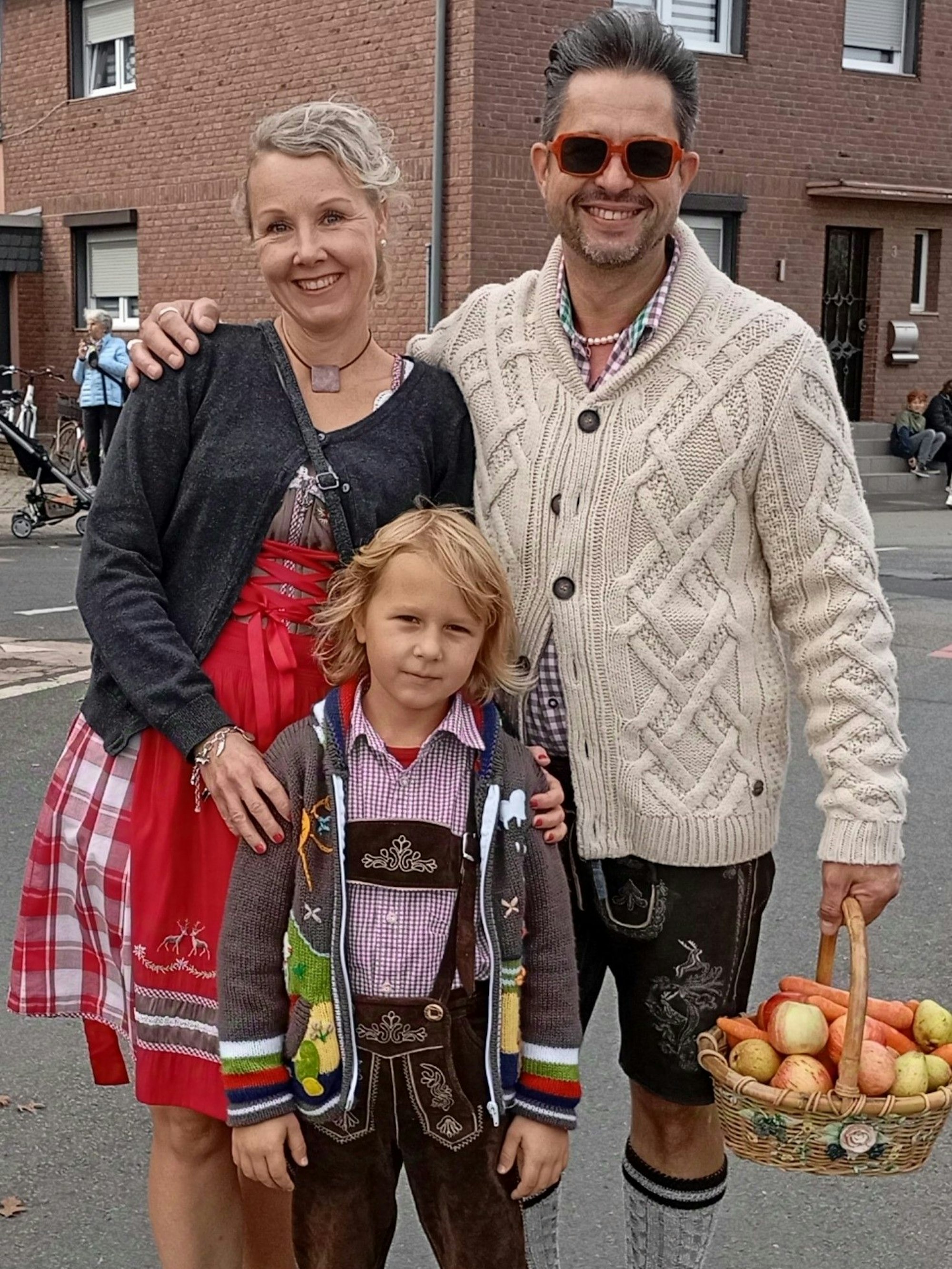 Das Bild zeigt festlich gekleidete Zuschauer am Straßenrand.