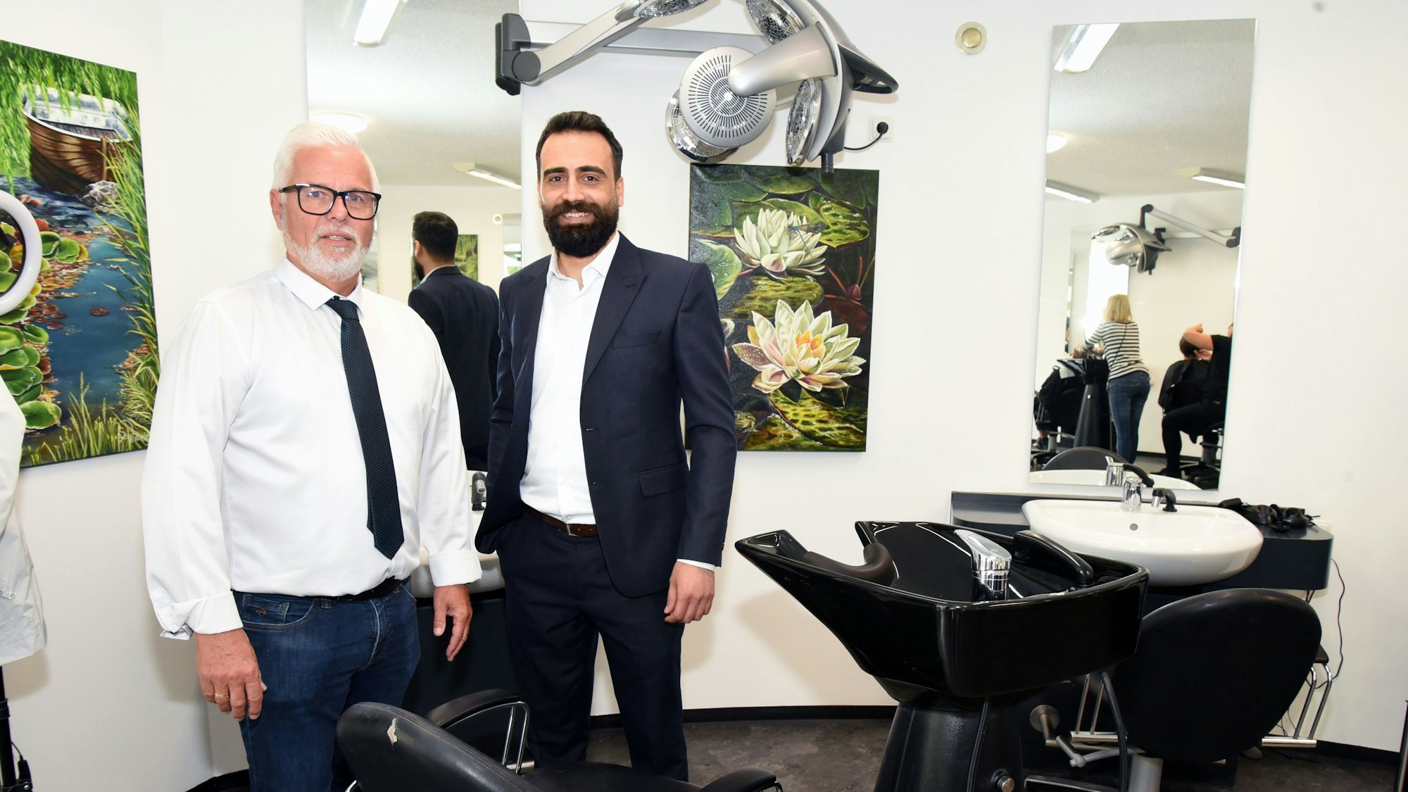 Zwei Männer stehen nebeneinander in einerm Friseursalon.