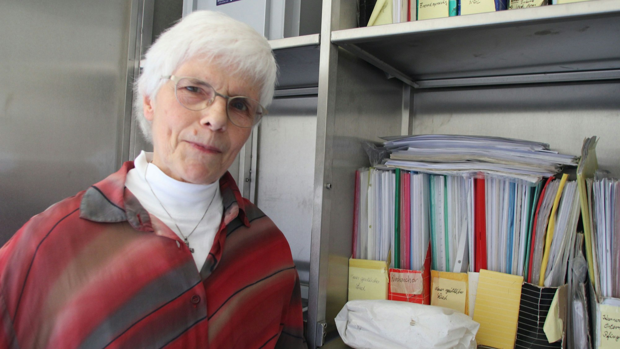 Lioba Lichtschlag 
steht vor dem Regal mit den Chornoten.