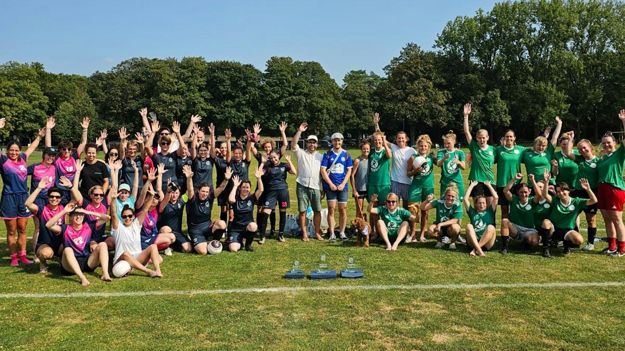 Frauenteams winken in die Kamera.