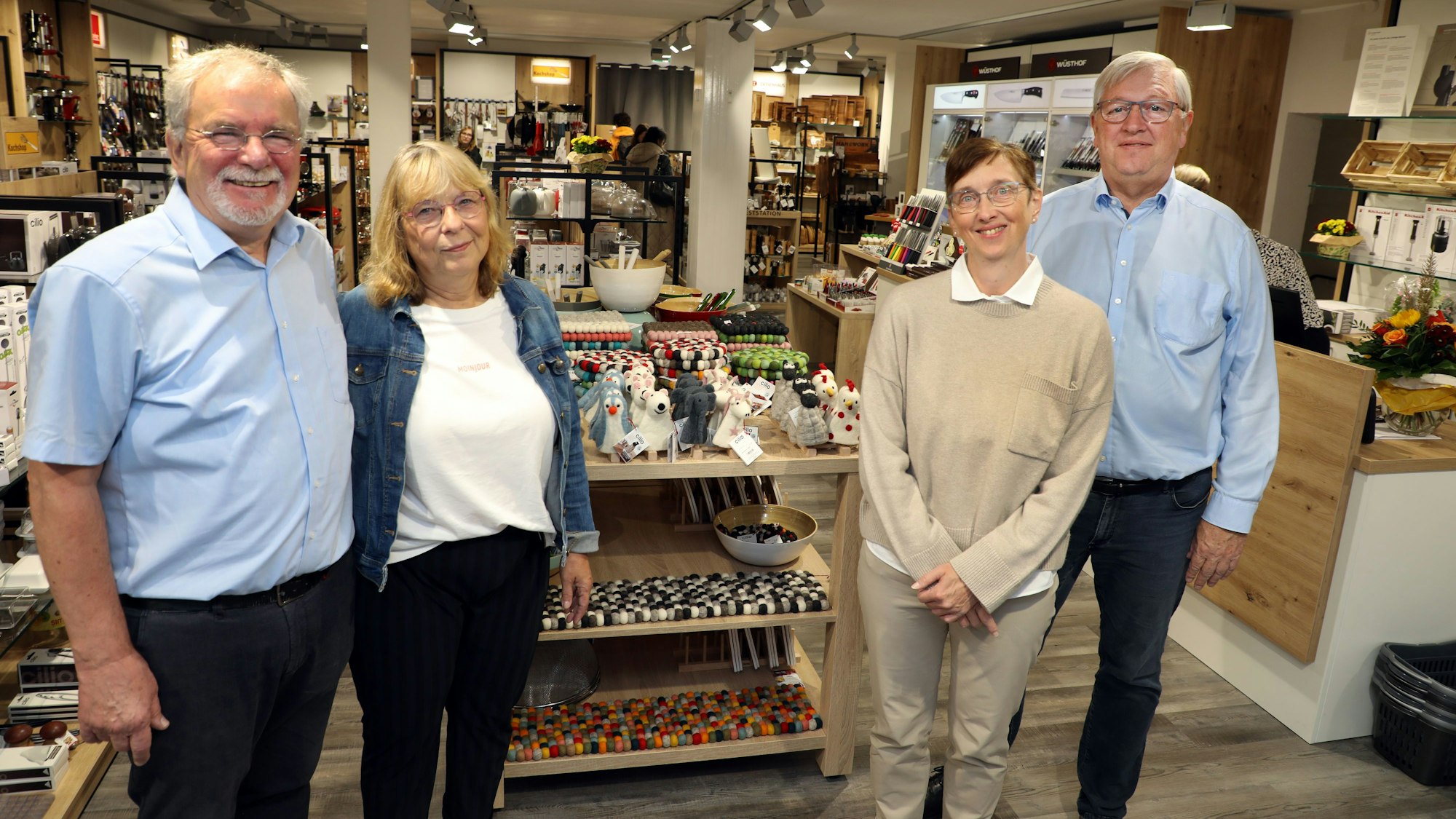 Die Inhaber der Kochshop-Kette, Stefan und Renate Schmitz aus Solingen, und die selbstständigen Betreiber der Filiale an der Bensberger Schloßstraße, Maria und Georg Daubenbüchel, stehen in der neuen Kochshop-Filiale an der Schloßstraße 68 in Bensberg.