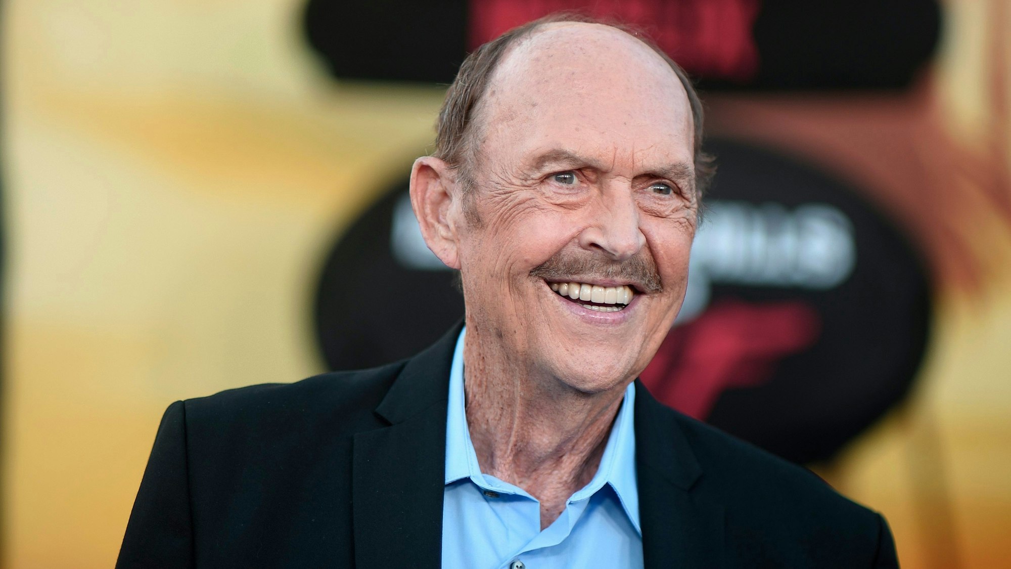 John Ashton lacht auf einer Filmpremiere.