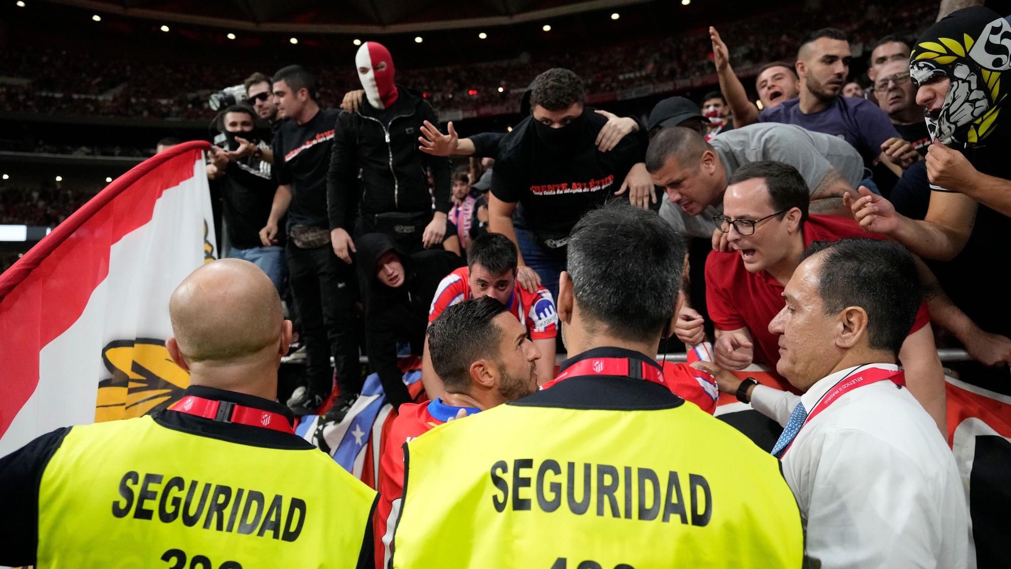 Aufgebrahte Fans von Atletico Madrid werden von den eigenen Spielern beruhigt.