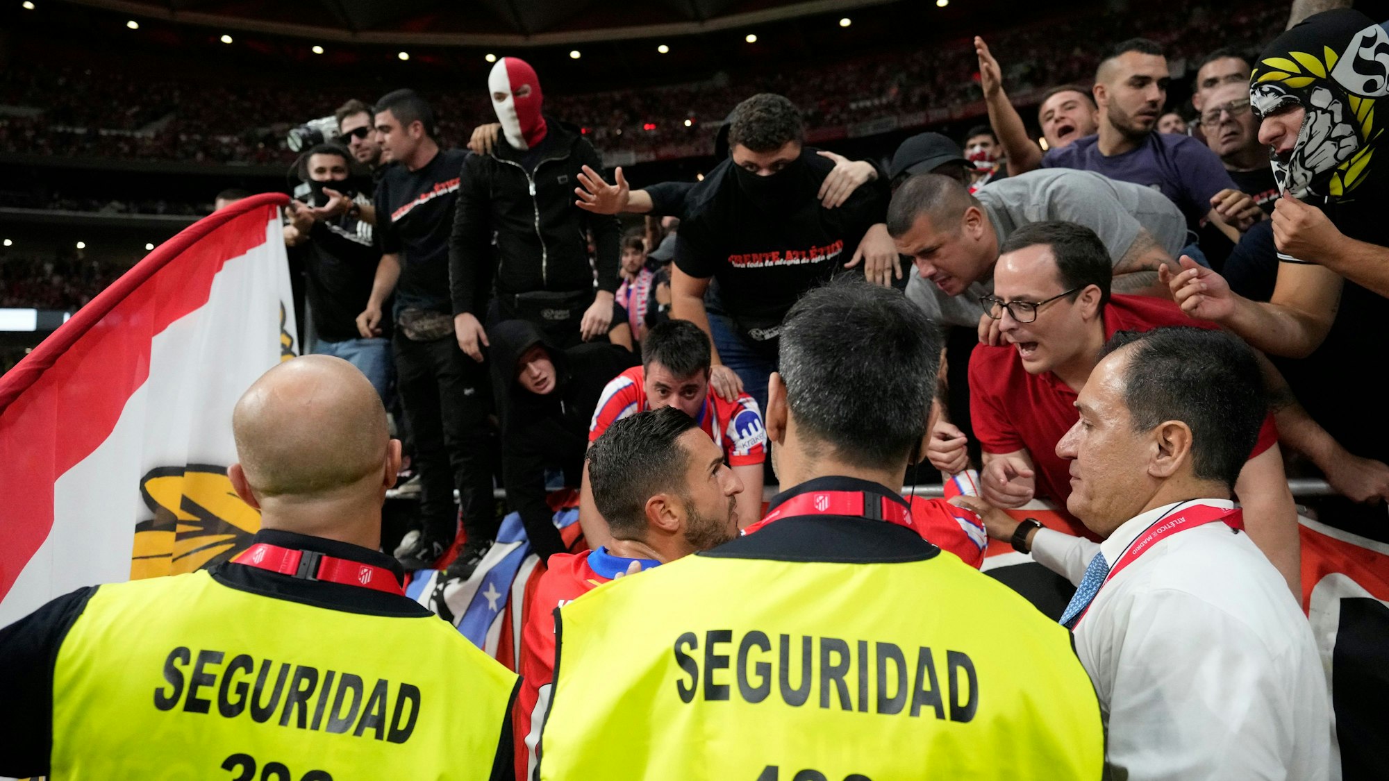 Aufgebrahte Fans von Atletico Madrid werden von den eigenen Spielern beruhigt.