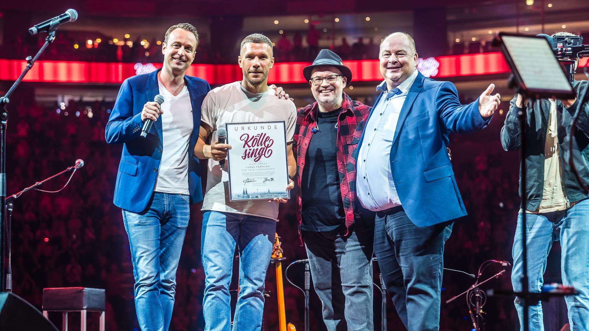 Podolski steht auf der Bühne von „Kölle singt“