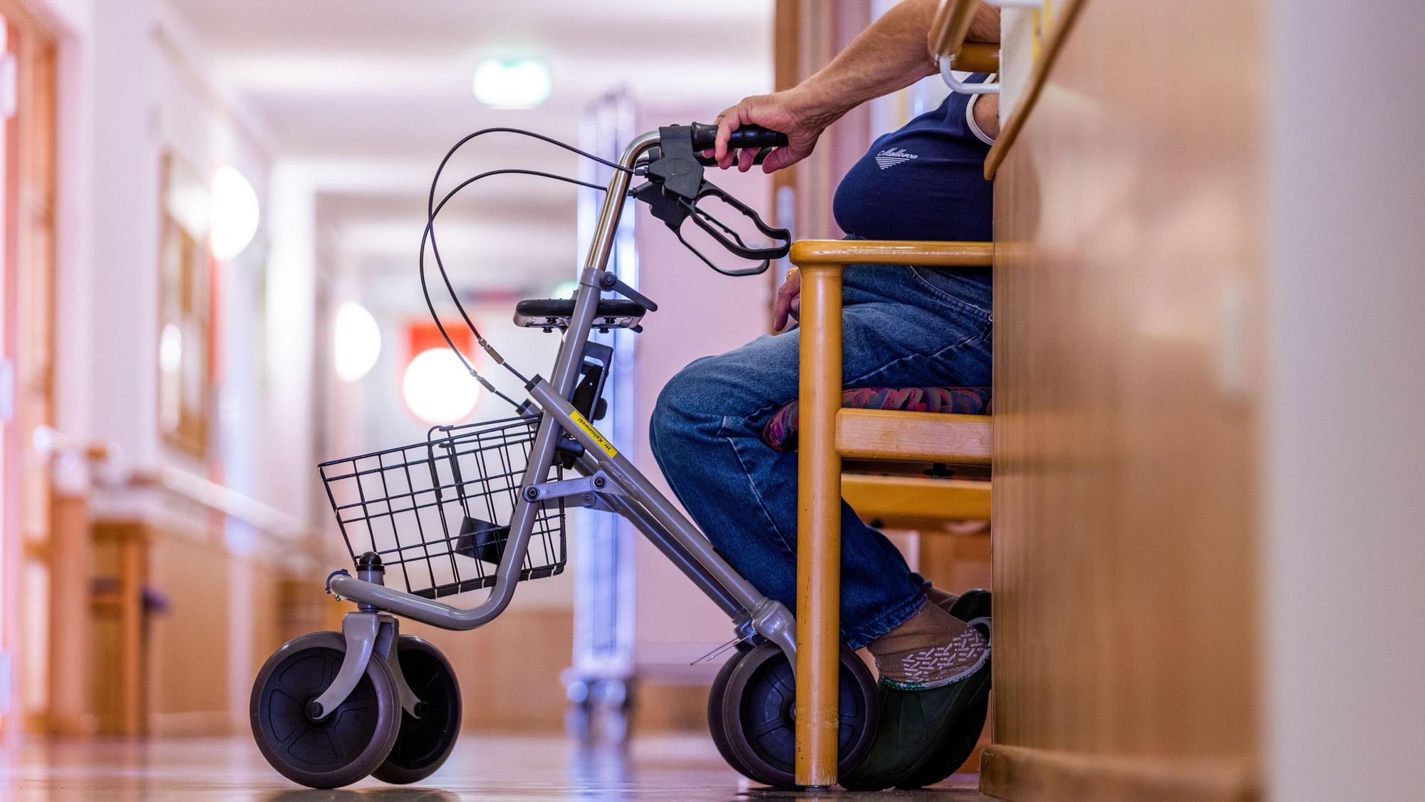 Eine Bewohnerin eines Altenheims mit Rollator, Person ist unkenntlich