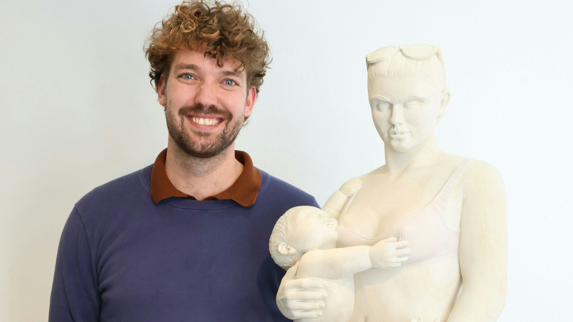 Joscha Bender steht neben seiner Skulptur „Madonna mit Pommes“.