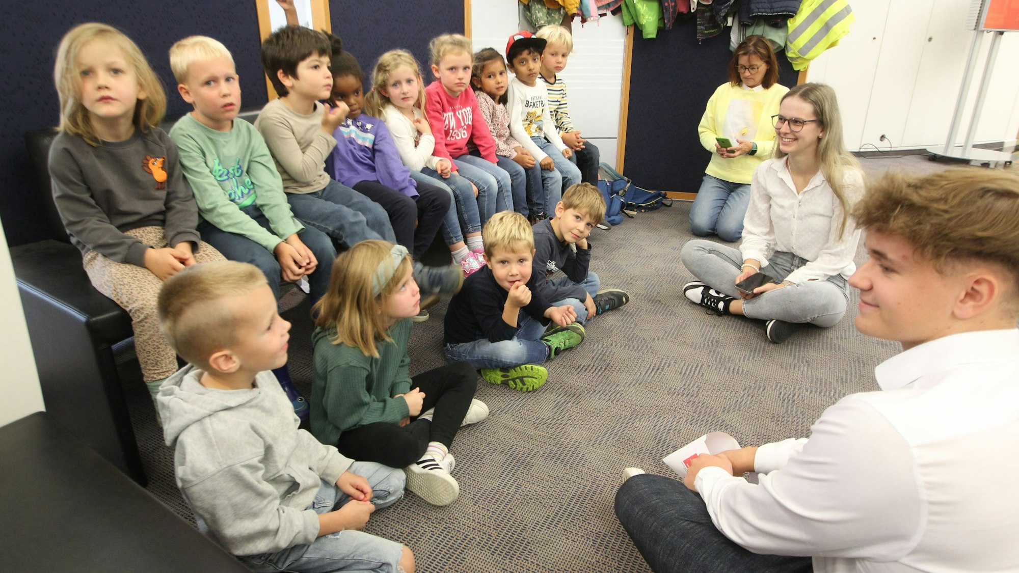 Alle Kinder lauschen den beiden KSK-Mitarbeitern Johanna Lohmar und Christian Schmeling.