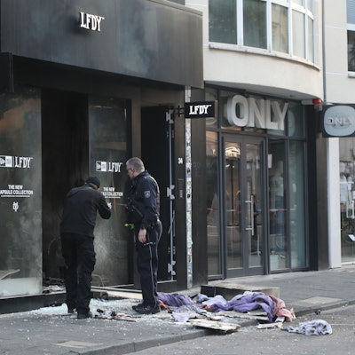 Ermittler stehen vor einem von einer Explosion erschütterten Geschäft auf der Ehrenstraße.