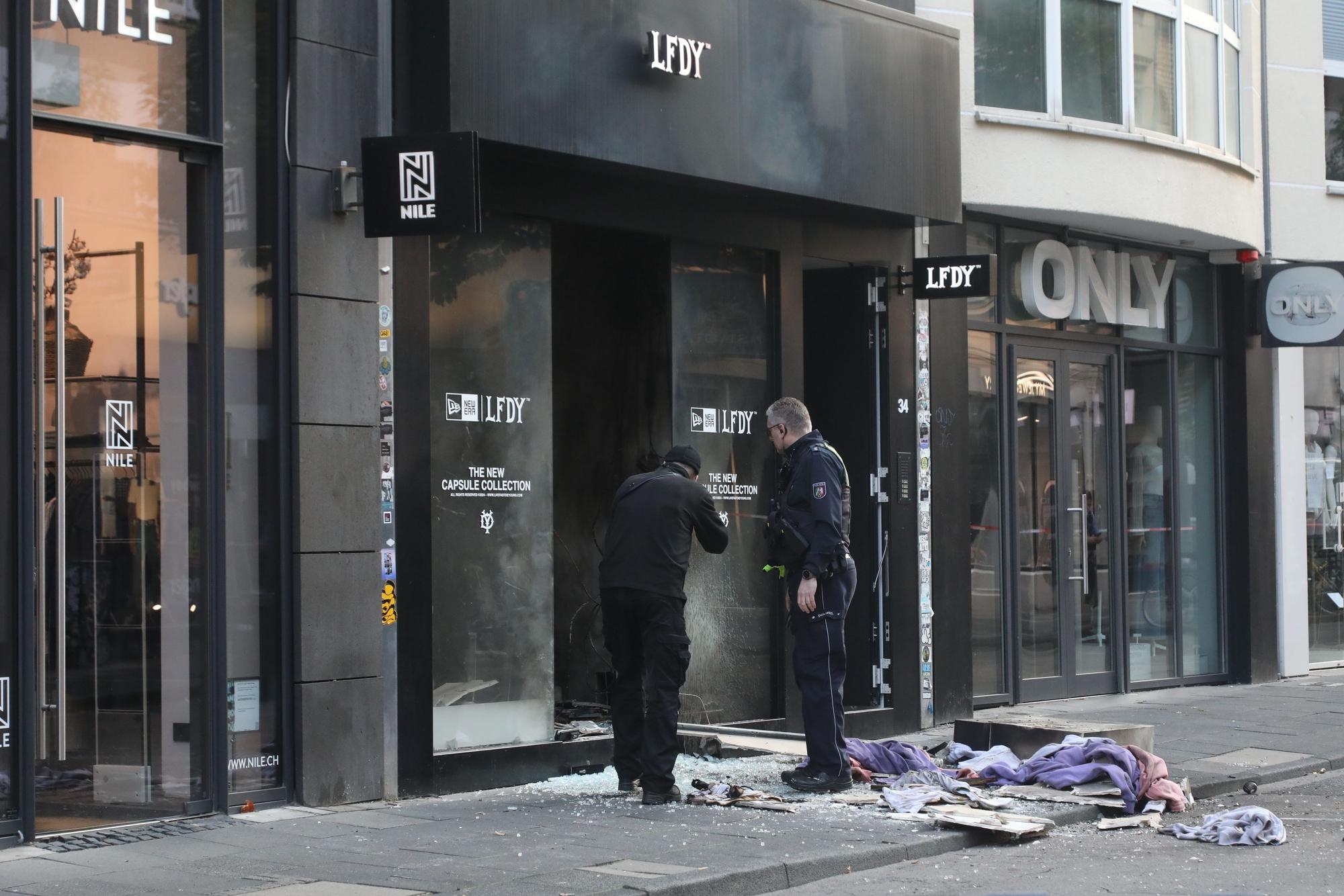 Ermittler stehen vor einem von einer Explosion erschütterten Geschäft auf der Ehrenstraße.