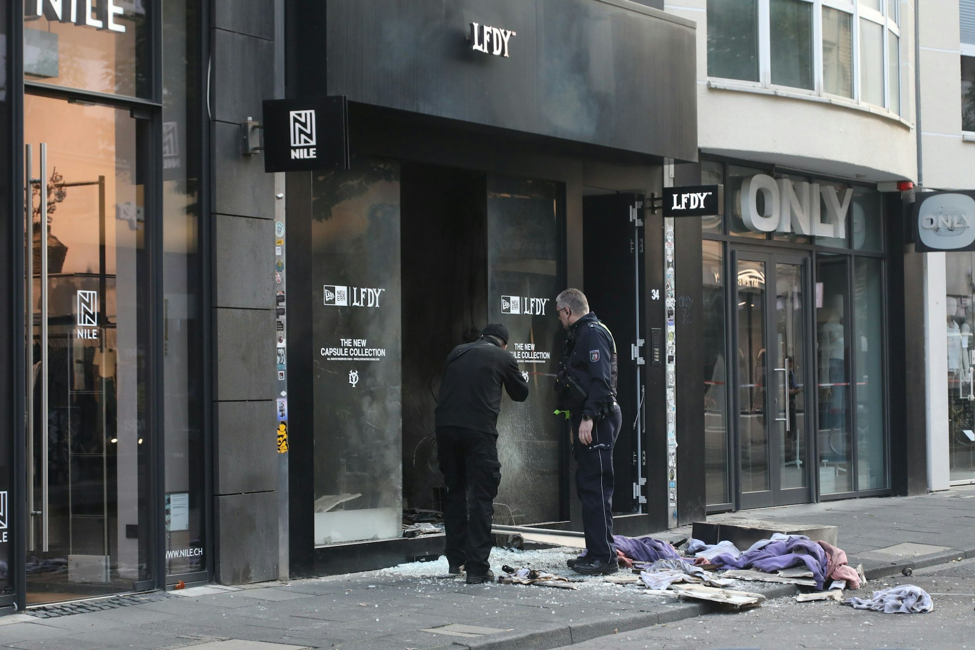Ermittler stehen vor einem von einer Explosion erschütterten Geschäft auf der Ehrenstraße.