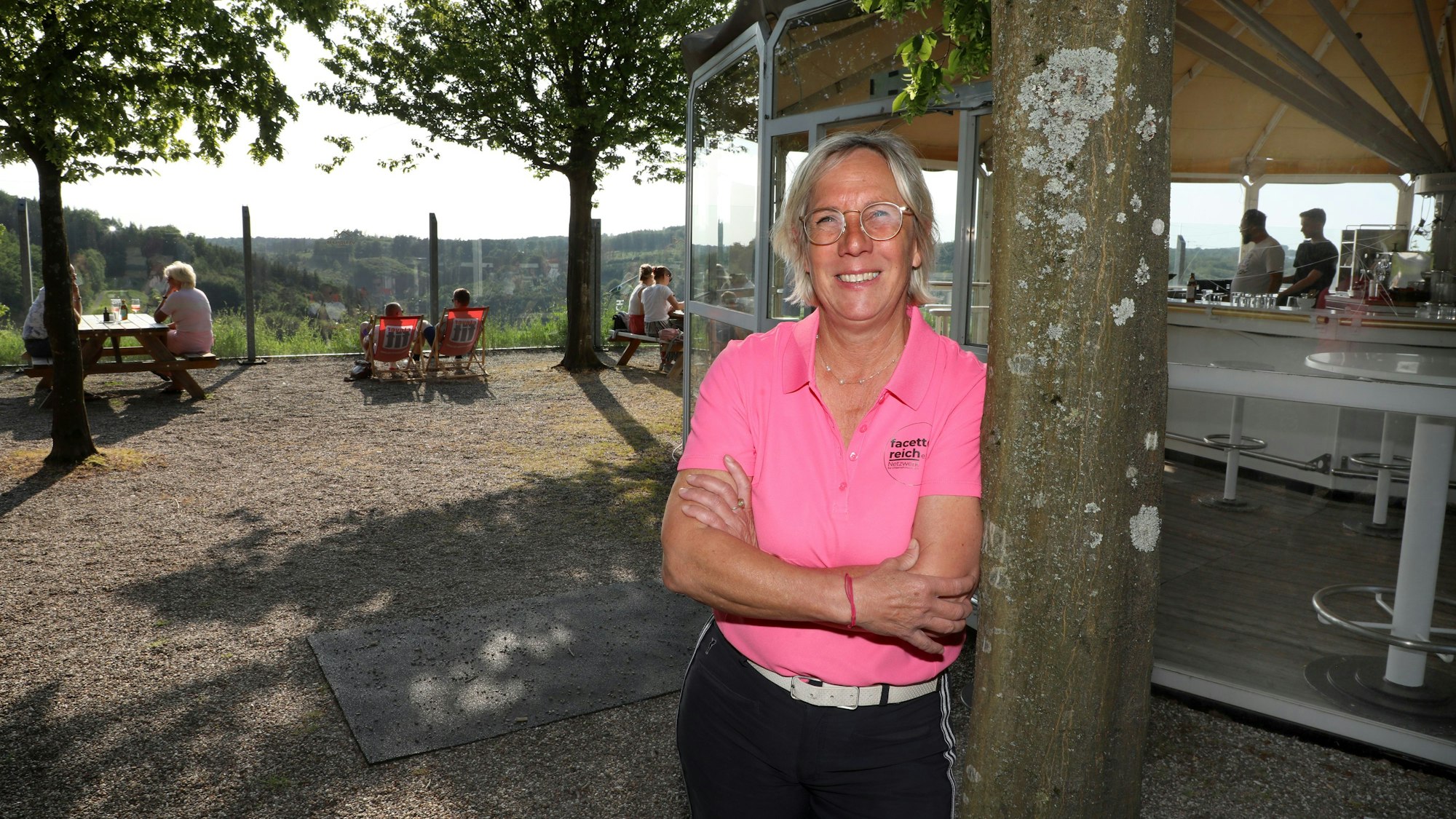 Sabina Henrich steht an einem Baum vor der Panoramabar auf dem Golfplatz „Der Lüderich“.