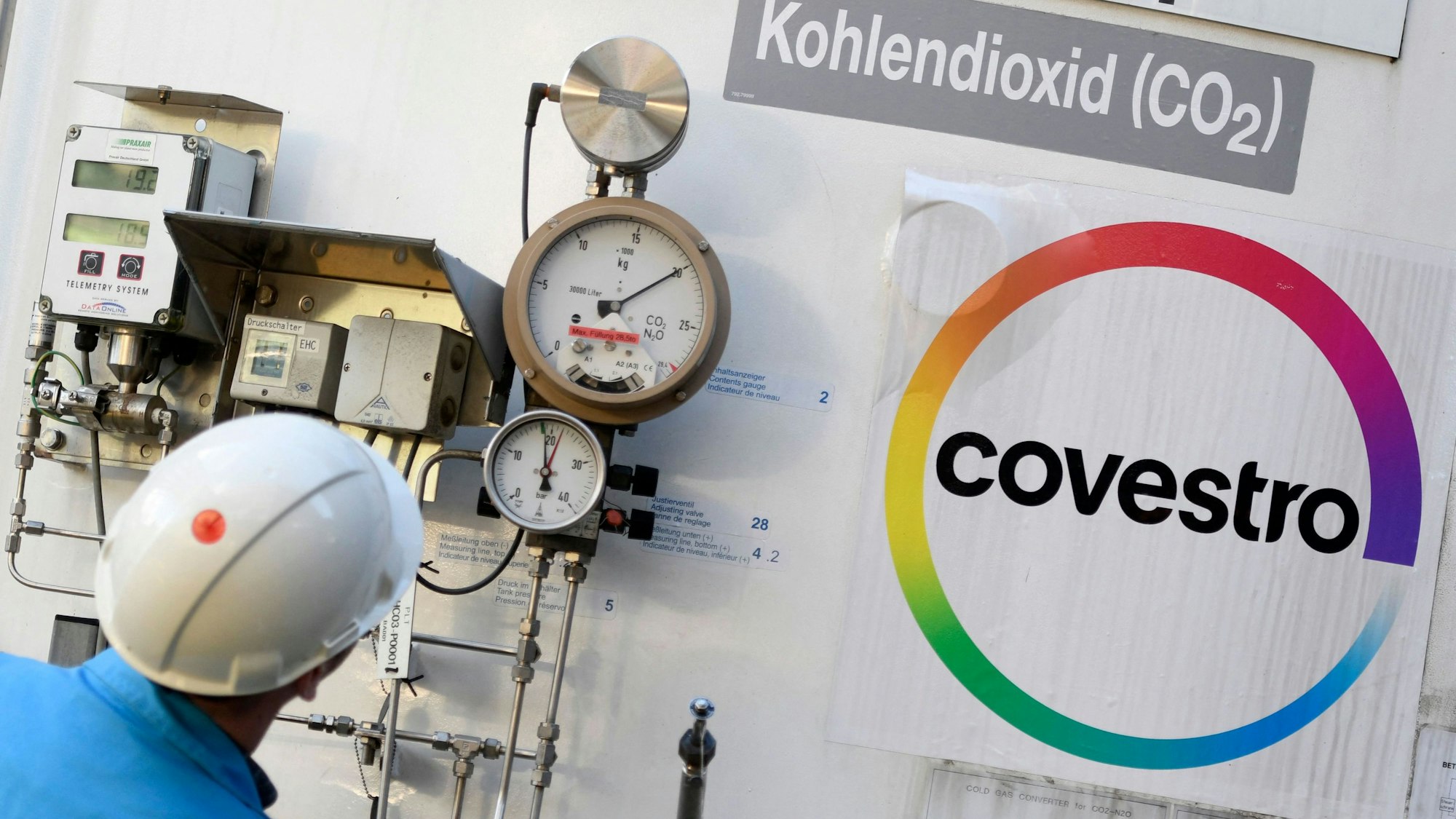 Arbeiter neben einem Logo von Covestro